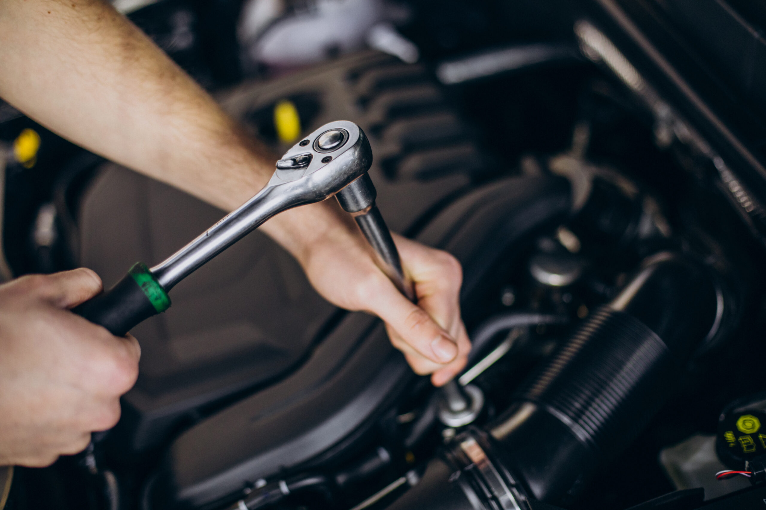 Automotive repair work being completed with hand tools