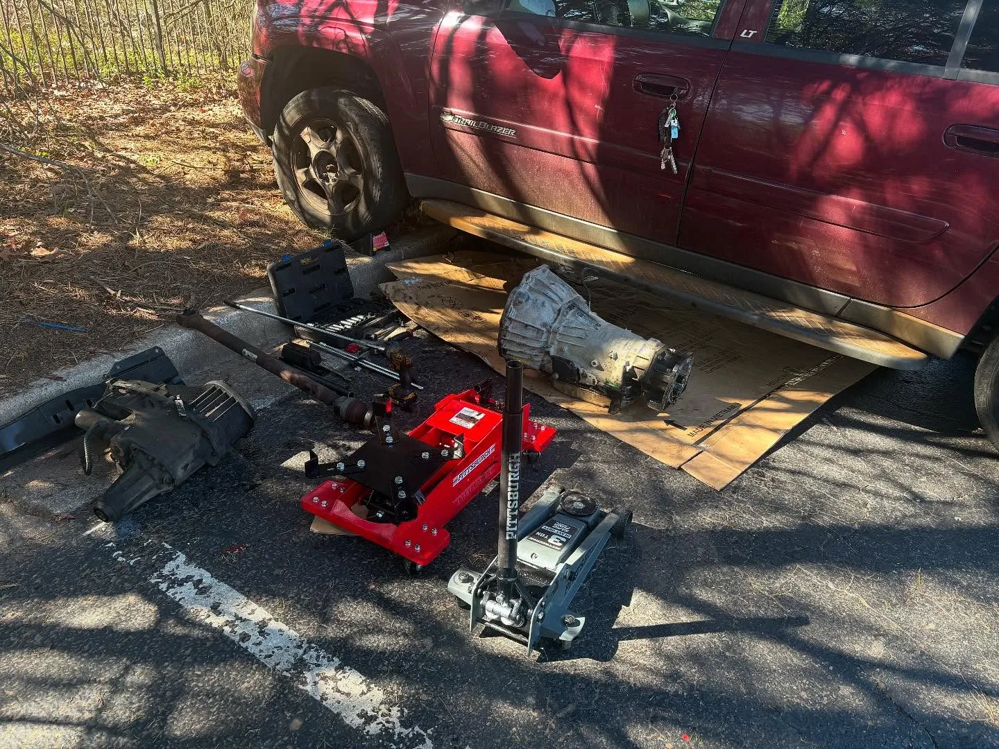 Transmission and automotive tools beside a Chevrolet TrailBlazer